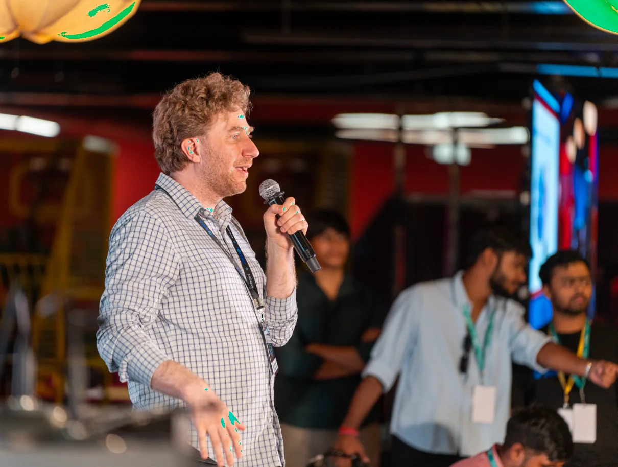 Y Combinator’s Jared Friedman speaking into a microphone at VibeCon 2026 on the Polaris campus